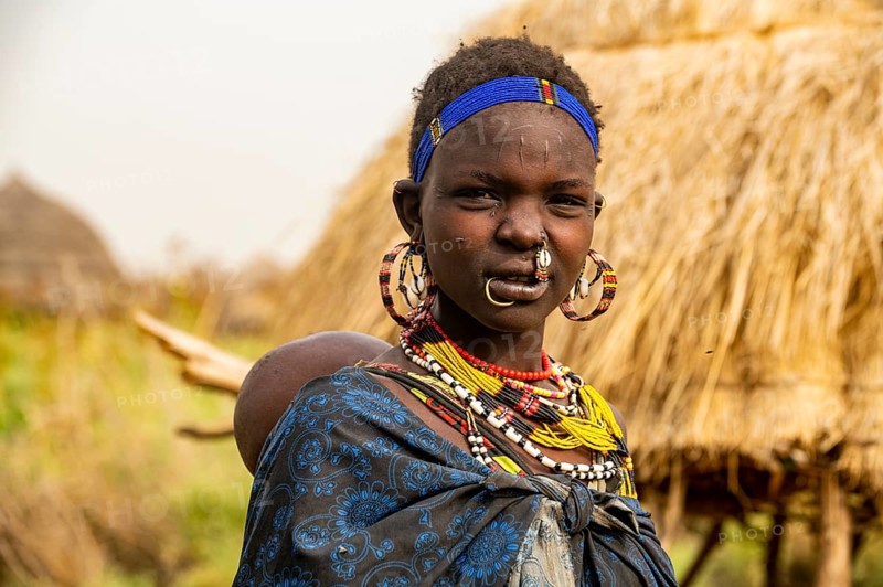 Woman with her child before her hut