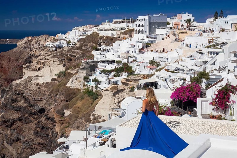 Woman in a blue dress looks over the place Imerovigli
