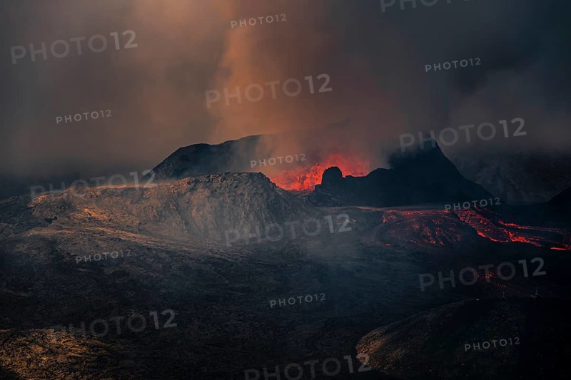 Erupting volcano with lava fountains and lava field
