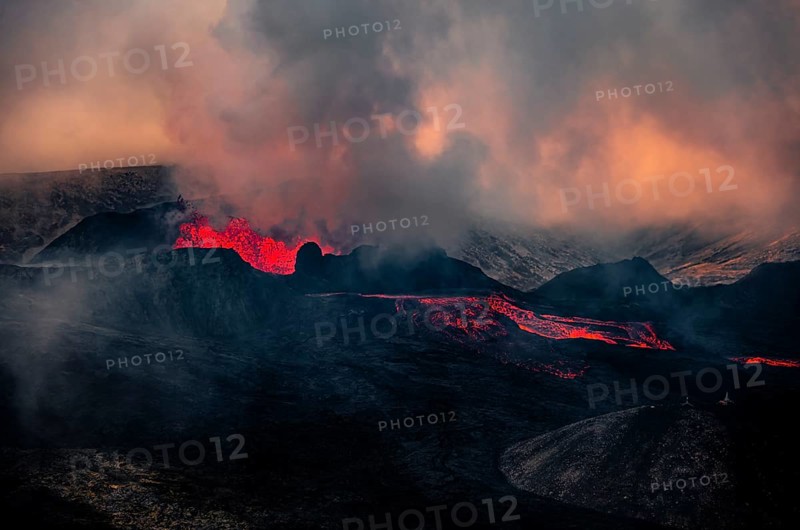 Erupting volcano with lava fountains and lava field
