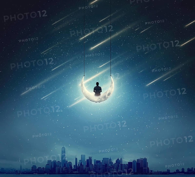 Surreal background with a boy sitting on a crescent moon