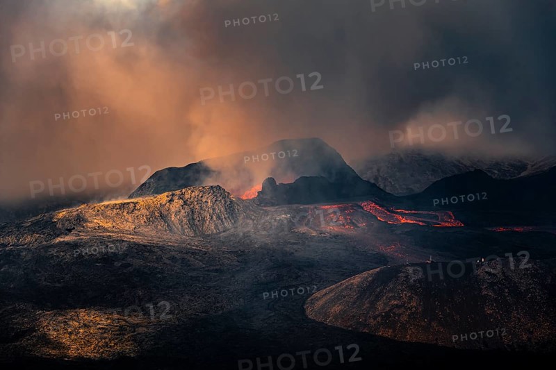Erupting volcano with lava fountains and lava field
