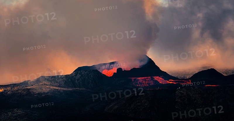 Erupting volcano with lava fountains and lava field