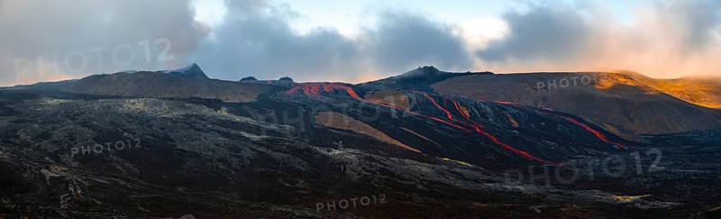 Erupting volcano with lava fountains and lava field