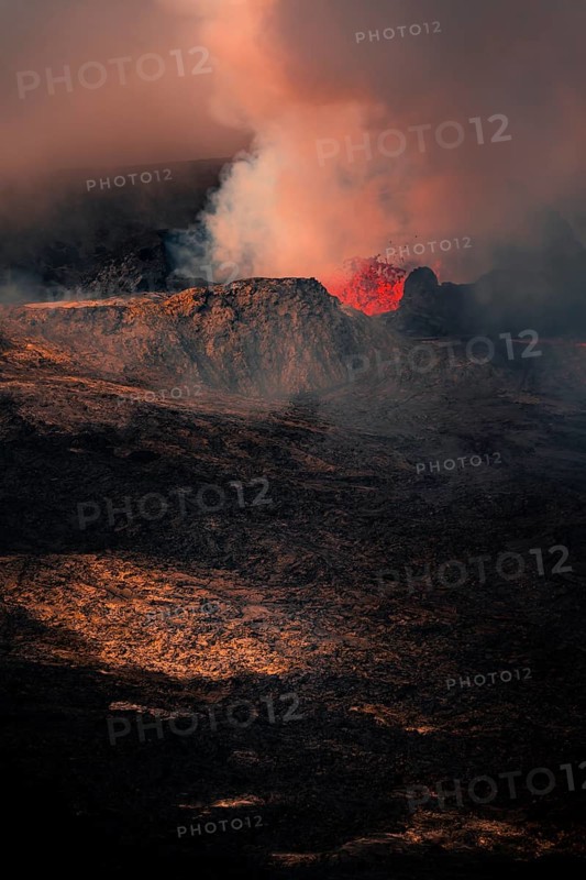 Erupting volcano with lava fountains and lava field