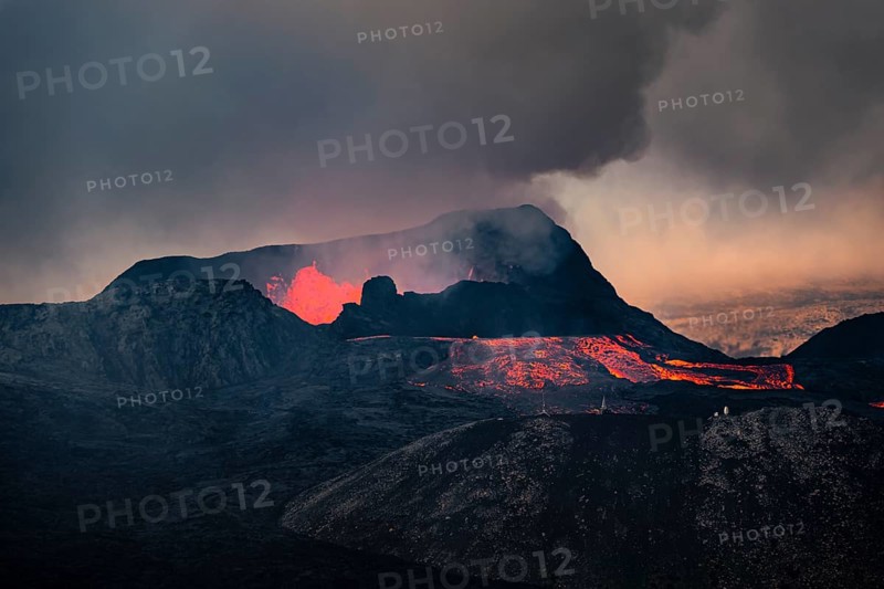 Erupting volcano with lava fountains and lava field