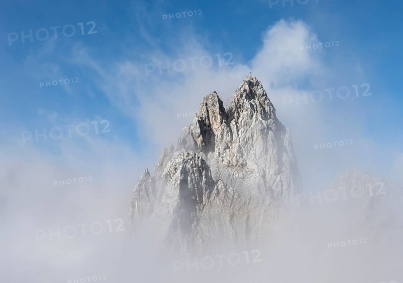 Rocky mountain peak between clouds
