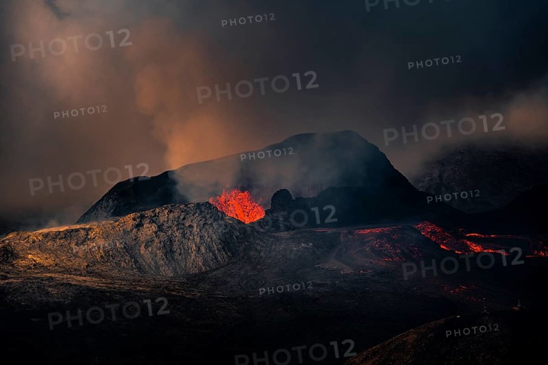 Erupting volcano with lava fountains and lava field