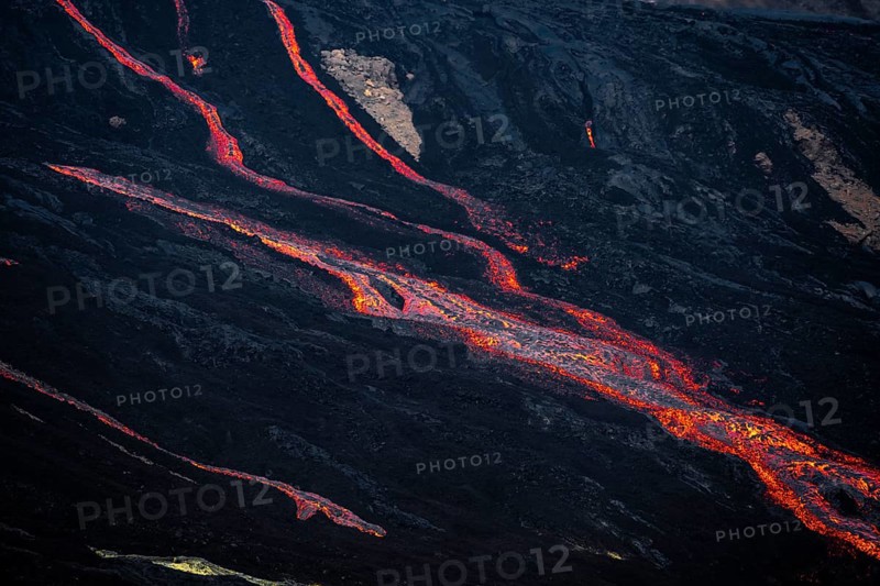 Erupting volcano with lava fountains and lava field