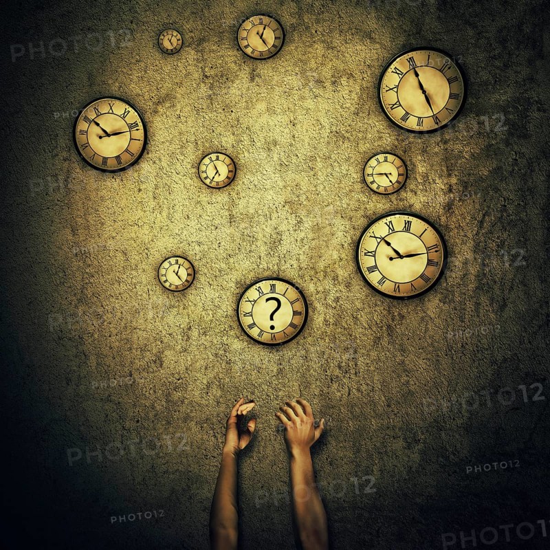 Abstract idea as human hands stretched out and juggling with a lot of clocks set to different times