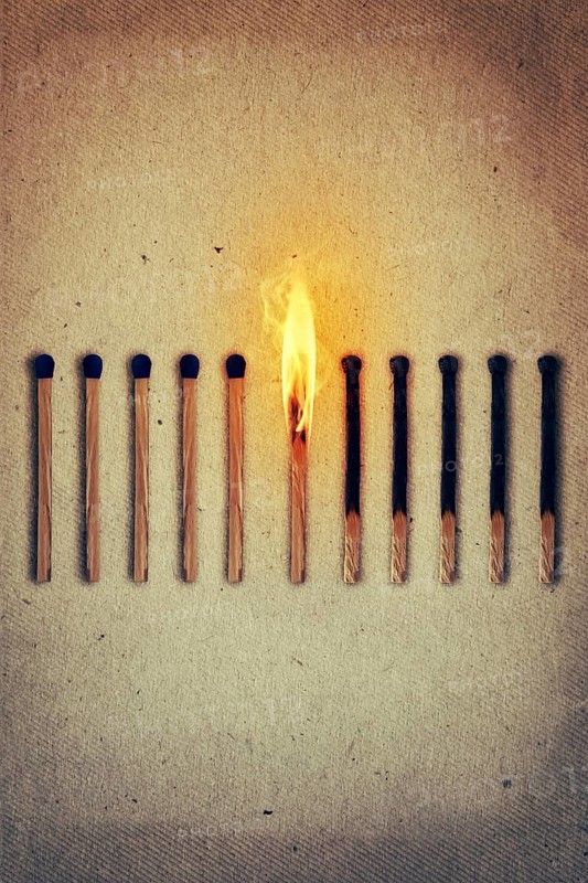 Burning match standing middle a row of whole