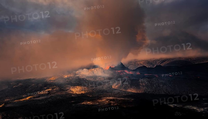 Erupting volcano with lava fountains and lava field