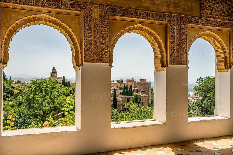 View of Nasrid Palaces through arches of Generalife Palace in Alhambra in Granada