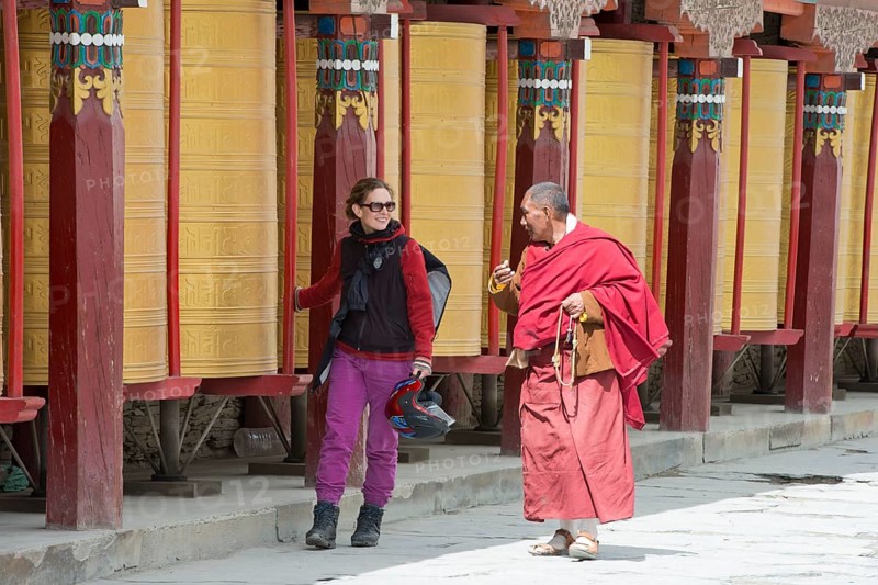 European young woman chatting with a Tibetan monk during the morning circumambulation