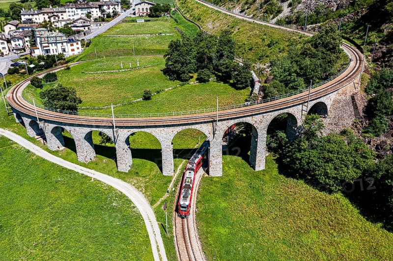 Aerial of a Train crossing the Brusio spiral viaduct