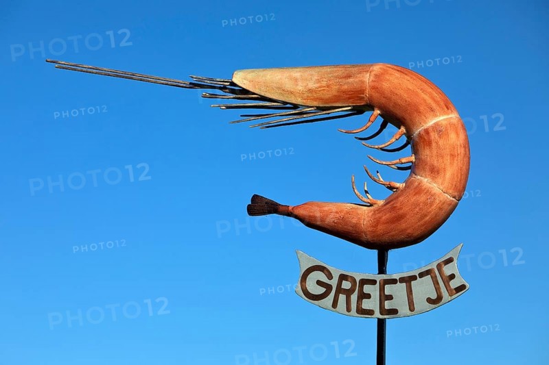 The sculpture of the North Sea crab Greetje at the fishing harbour against a blue sky