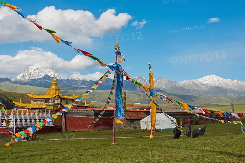Golden roofs and chorten of a Tibetan monastery in the grassland of Tagong in front of Mount Zhara Lhatse