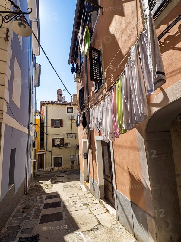 Laundry hanging to dry in a narrow alleyway of the old town of Izola