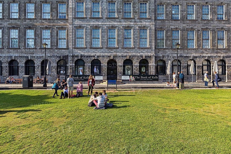 Students on a lawn in front of the library of Trinity College