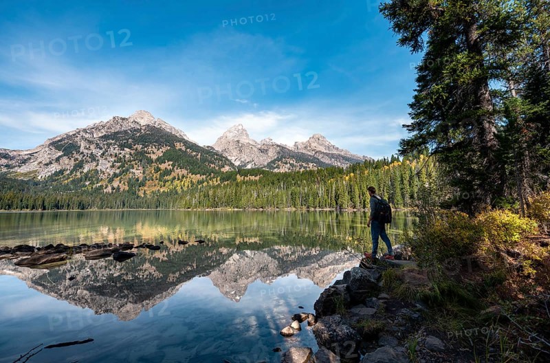 Young man standing by a lake