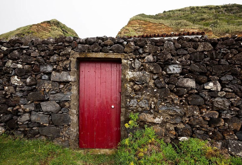 Lava stone garden wall with red front door