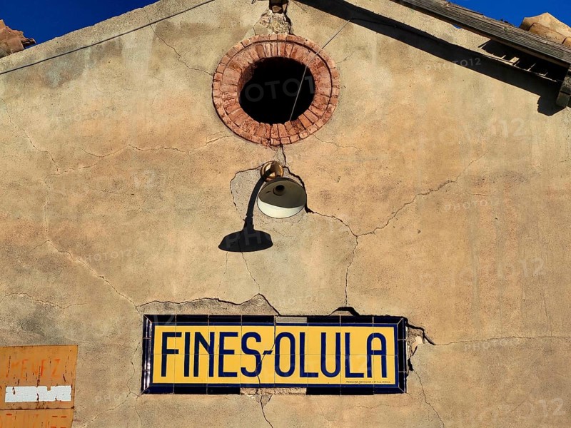 Station building with broken lamp and place name made of tiles