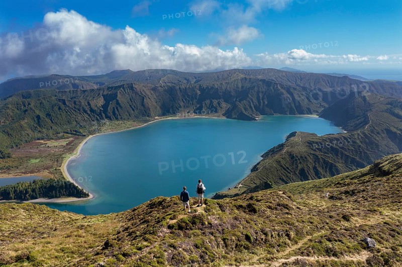 Hikers at the summit of Pico Barrosa with view to the crater lake Lagoa do Fogo