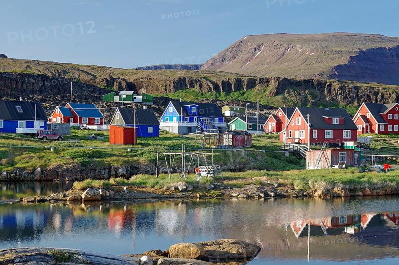 Wooden houses reflected in a calm body of water
