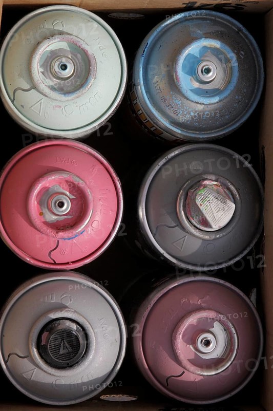 Six colourful spray cans in cardboard box