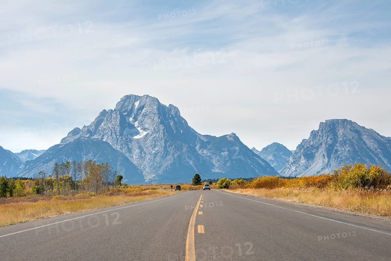 Country road in front of Grand Teton Range mountain