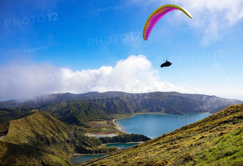 paraglider in flight over the crater lake Lagoa do Fogo