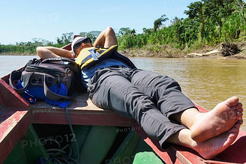 Tourist lying on the bow of a longboat