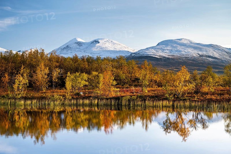 Snowy mountains in Abisko National Park reflected in lake Vuolio Njahkajavri