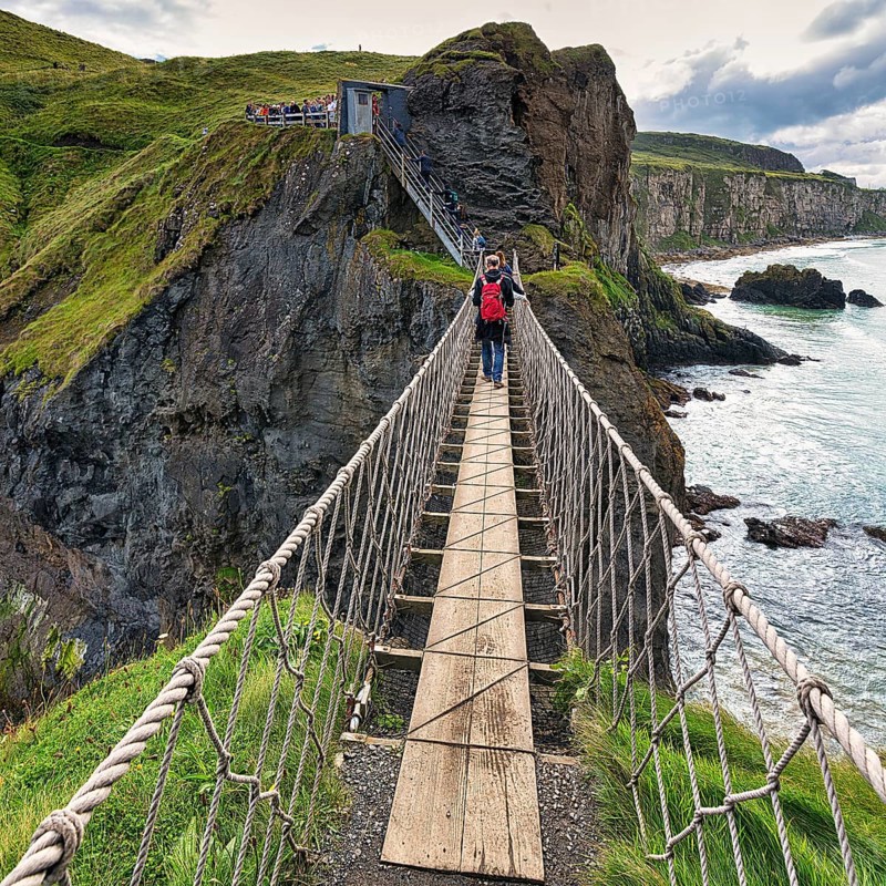 Narrow suspension bridge for pedestrians on rocky coast