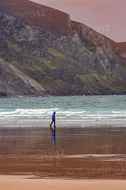 Walker walking along the beach in the evening