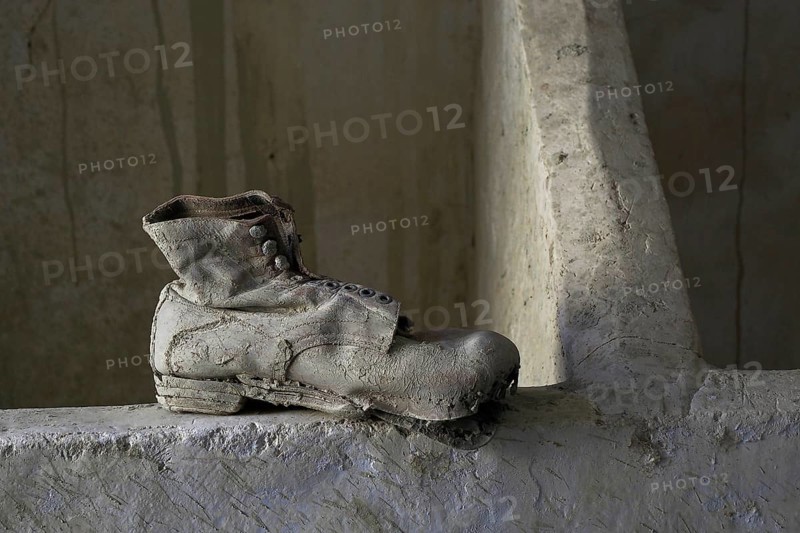 Old work shoe on the floor in front of wooden block