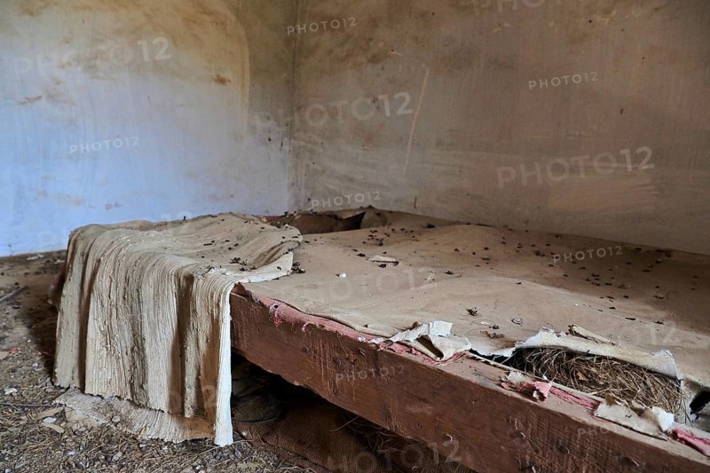 Demolished bed frame with blanket and pigeon droppings