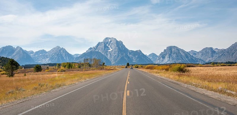 Country road in front of Grand Teton Range mountain