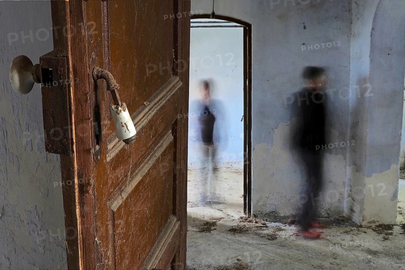 Open door with two people in abandoned house