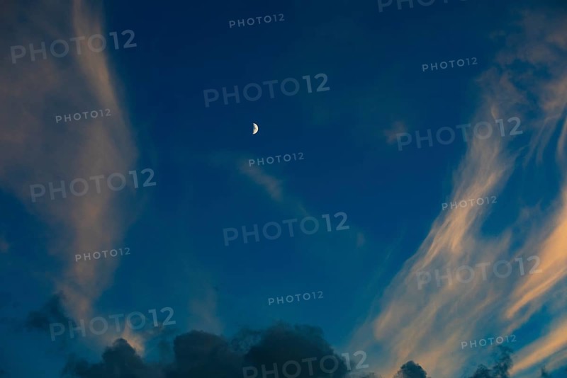 Evening sky with clouds and half moon