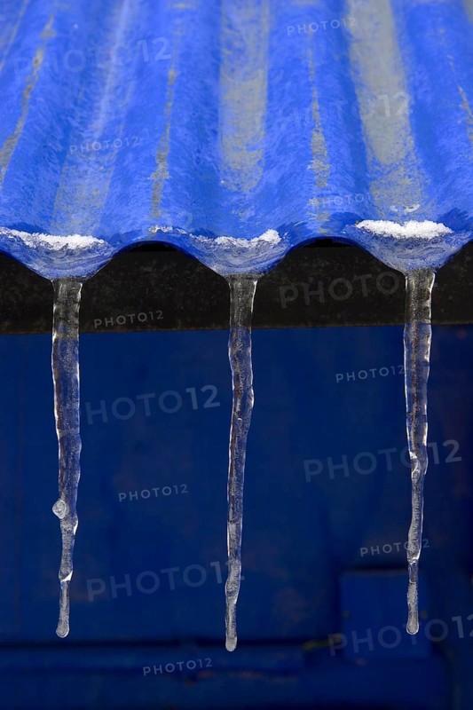 Three icicles on roof of blue corrugated iron