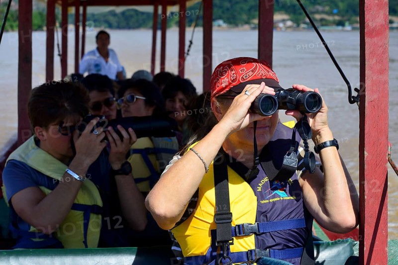 Tourist with binoculars in a longboat