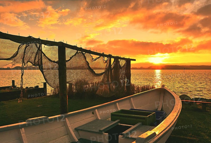 Suspended fishing nets and fishing boat in the sunset