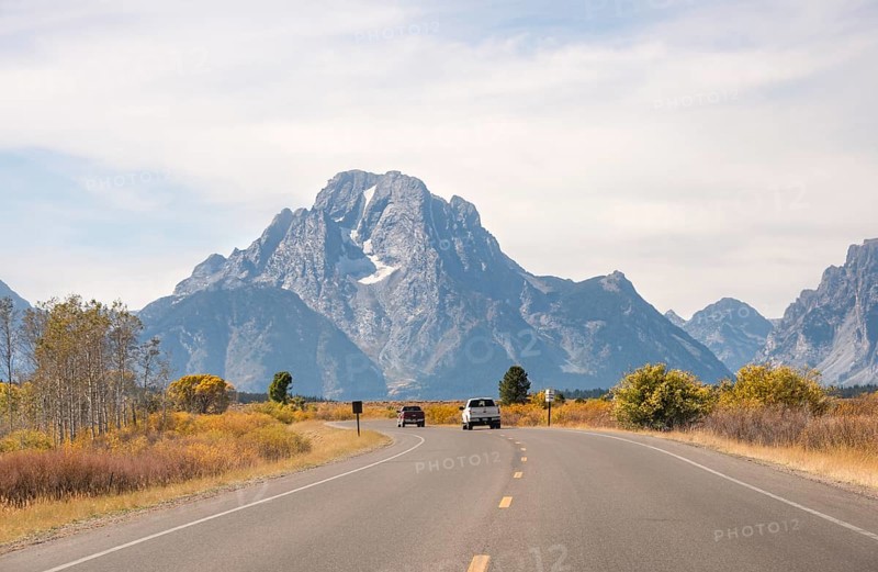Country road in front of Grand Teton Range mountain
