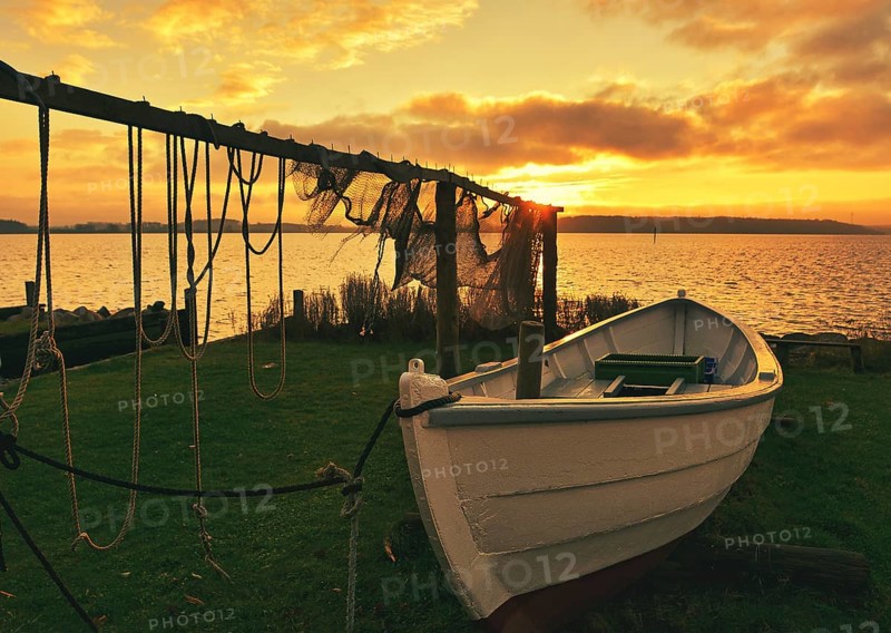 Suspended fishing nets with fishing boat in the sunset