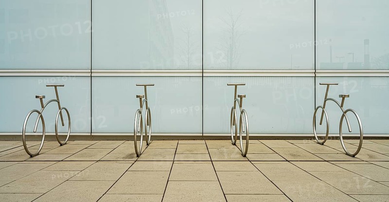 Design of aluminium bicycles in front of a bright plastic wall