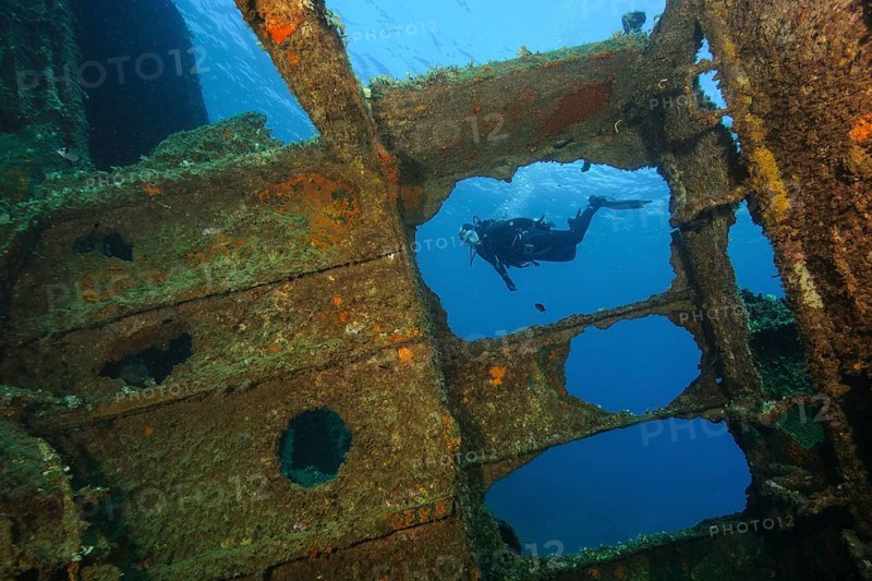 Diver looking into interior of sunken ship decaying rusting shipwreck Elviscot