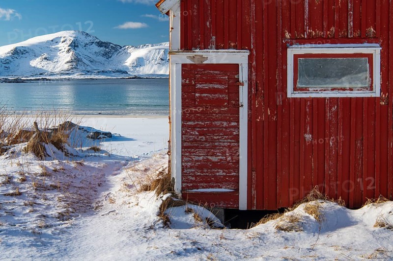 Red boathouse in winter Scandinavian landscape