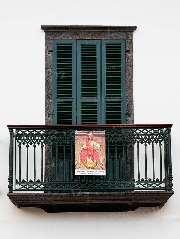 House facade with balcony and image of a saint