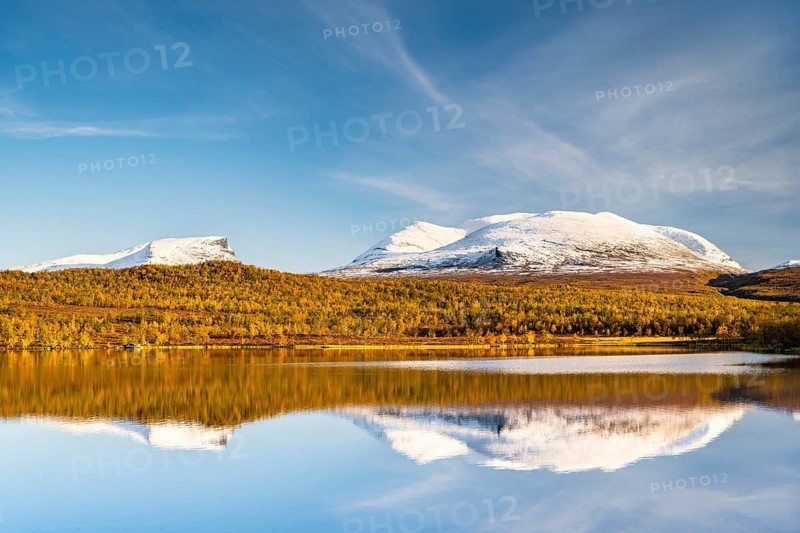 Snowy mountain group Lapporten reflected in lake Vuolio Njahkajavri